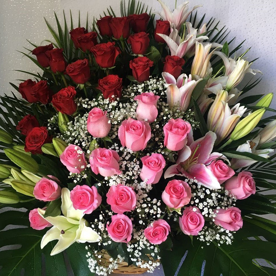 Lilies and South African or Kenyan Roses with baby’s breath in a basket - Real Flowers Pakistan