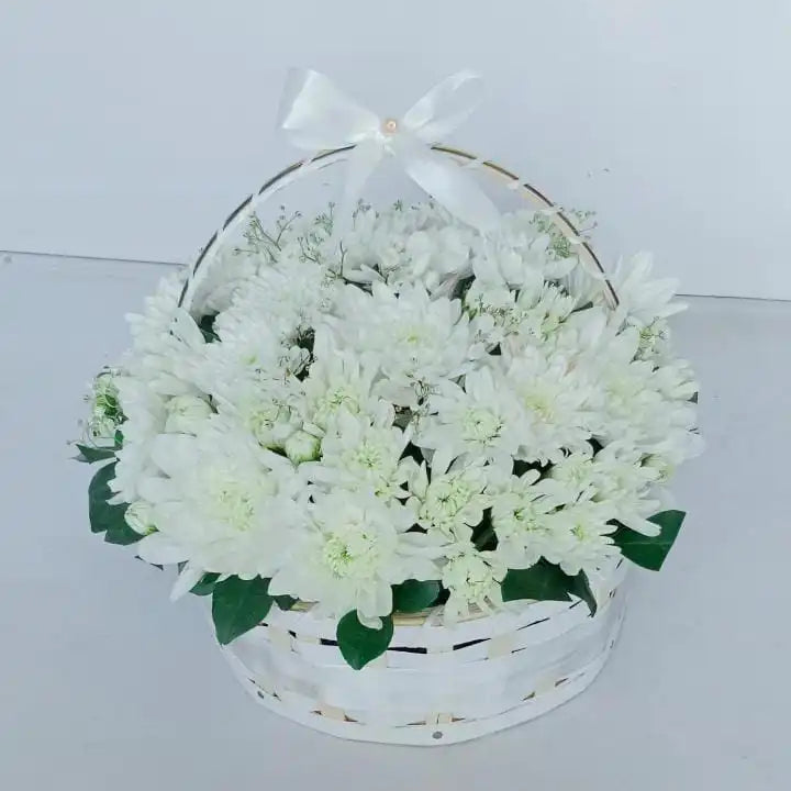 A Gift Basket of white Chrysanthemum flowers with green leaves and a bow ribbon - Realflowers.pk