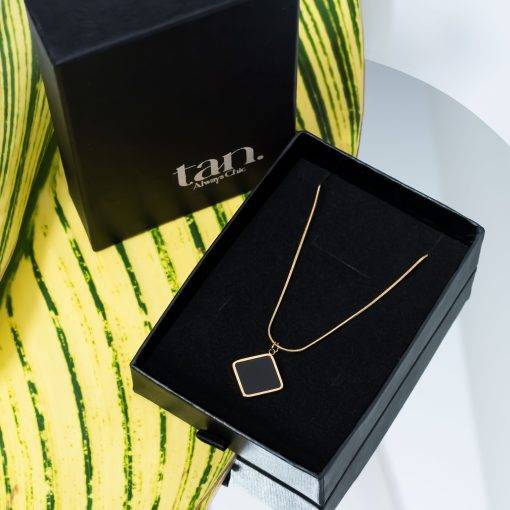 Black Mirage Necklace with square black shell pendant and gold-tone stainless steel finish in black box lable tan